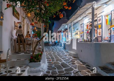 Mykonos, Griechenland, 26. September 2020: Nachtansicht von Touristenläden in einer engen Straße in der Altstadt von Mykonos, Griechenland Stockfoto