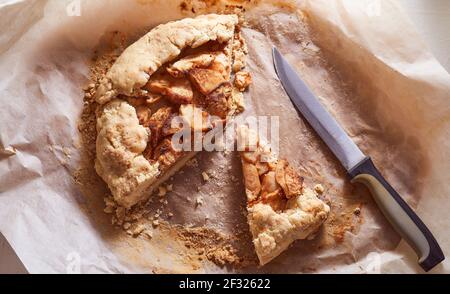 Hausgemachter Apfelkuchen auf Minzpapier Hintergrund mit Stahlmesser. Hochwertige Fotos Stockfoto