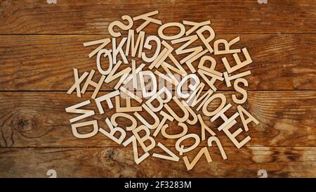 Holzbuchstaben auf Holzhintergrund. Die Buchstaben des englischen Alphabets. Stockfoto