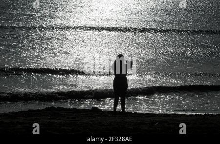 Palma, Spanien. März 2021, 14th. Eine Frau in der Nähe des Mittelmeers am Strand von Arenal. Aufgrund der geringen Inzidenz von Coronaviren ist Mallorca kein Risikogebiet mehr. Quelle: Clara Margais/dpa/Alamy Live News Stockfoto