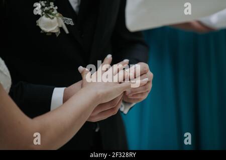 Das unverkennbare Paar tauscht während der Hochzeitszeremonie Ringe aus Stockfoto