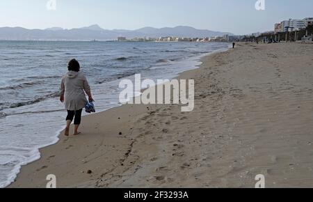 Palma, Spanien. März 2021, 14th. Eine Frau spaziert am Strand von Arenal auf Mallorca. Aufgrund der geringen Inzidenz von Coronaviren ist Mallorca kein Risikogebiet mehr. Quelle: Clara Margais/dpa/Alamy Live News Stockfoto