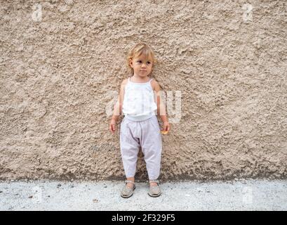 Baby Mädchen im Sommer agaisnt eine Wand Stockfoto