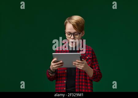 Kind Junge in rot kariert Hemd mit digitalen Tablet Stockfoto