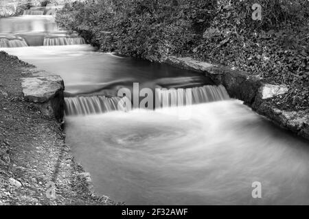 Rauschende Wasser in Wasserfall Stromschnellen in langer Exposition als gefangen Wasser bewegt sich über Felsen Stockfoto