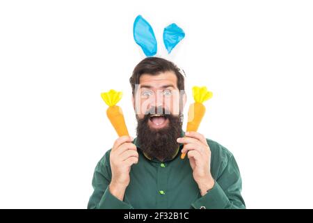 Verspielt gut aussehend. Überrascht Bunny Kerl mit Karotte. Frohe osterferien. Lustige Mann in Kaninchenohren Stockfoto