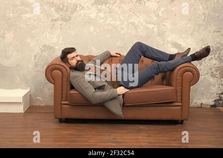 So sieht das Vertrauen im Menschen aus. Bärtiger Mann entspannen sich auf dem Sofa. Brutaler Mann in Business Casual. Modetrend. Modischer Style. Unrasiert Mann mit Stockfoto
