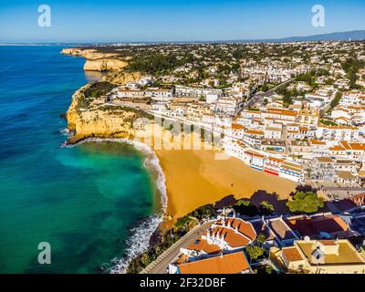 Luftaufnahme des breiten Sandstrands und der traditionellen Architektur von Carvoeiro an der Algarve, Portugal Stockfoto