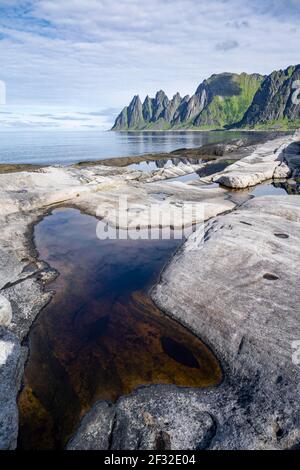 Gezeitenbecken, felsige Küste von Tungeneset, felsiger Gipfel Teufelszähne, Teufelszähne, Okshornan, Steinfjorden, Senja Island, Troms, Norwegen Stockfoto