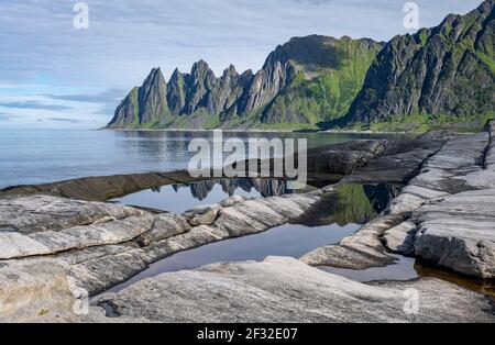 Gezeitenbecken, felsige Küste von Tungeneset, felsiger Gipfel Teufelszähne, Teufelszähne, Okshornan, Steinfjorden, Senja Island, Troms, Norwegen Stockfoto