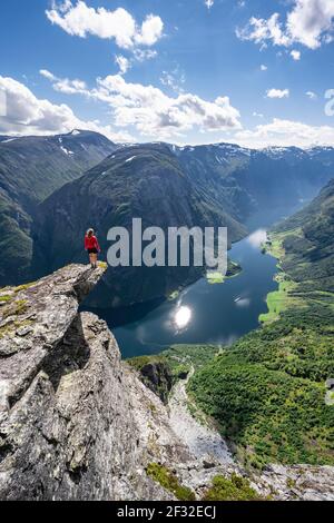 Wanderer stehen auf felsigen Ausbisse, Blick von der Spitze des Breiskrednosi, Berge und Fjord, Naeroyfjord, Aurland, Norwegen Stockfoto