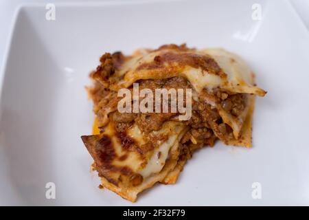 Lasagne in einem weißen Teller auf weißem Hintergrund Stockfoto