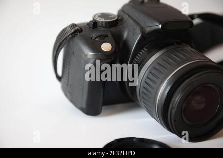 Eine gebrauchte Digitalkamera im Stil Mitte 2000s mit Tragegurt Vor weißem Hintergrund Stockfoto