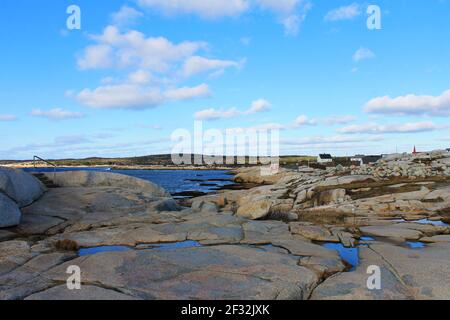 Graue Felsen, die von den Wellen glatt getragen werden, entlang der zerklüfteten Küste von Nova Scotia in Peggy's Cove. Stockfoto