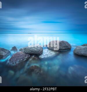 Felsen, weiches Meer und Wolken am Himmel, schöne Landschaft in Langzeitbelichtung Fotografie. Castiglioncello, Toskana, Italien. Stockfoto