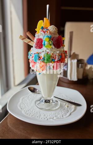 Crazy Shake auf der Oberseite mit einer Erdbeermarmelade und Süßigkeiten Und Marmeladenbären auf einem hellen farbigen Hintergrund Stockfoto