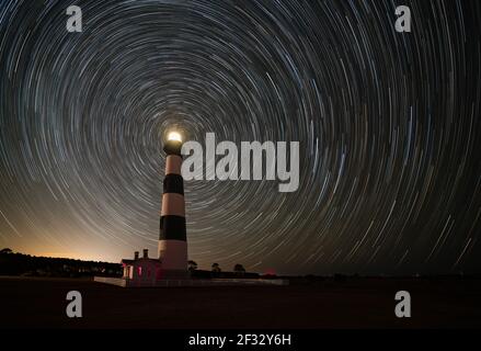 Sterne wirbeln um Polaris am Nachthimmel vor dem Bodie Island Lighthouse am äußeren Ufer von North Carolina, Nag's Head Stockfoto