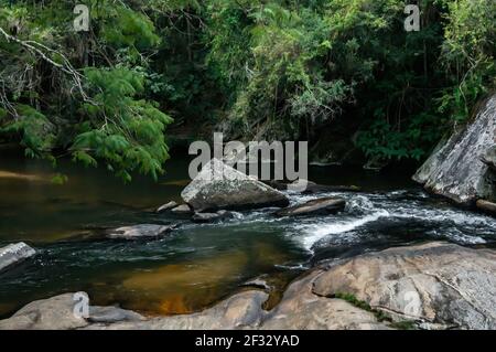 Der Pimenta Wasserfall fließt zwischen Felsen in einen natürlichen Pool im mittleren Sea Ridge (Serra do Mar) Wald. Stockfoto