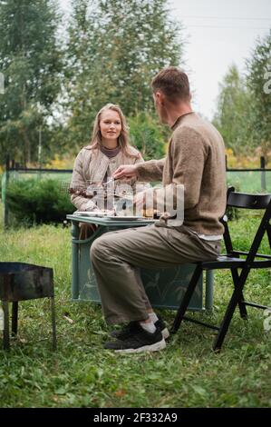 Ein Mann bereitete einen leckeren Kebab für seine Frau zu. Ein junges Paar zog sich im Urlaub in einem Landhaus zurück, um Zeit miteinander zu verbringen. Stockfoto