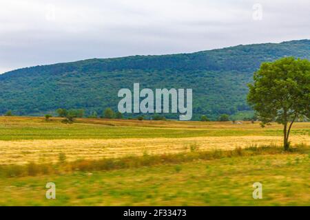 Natürliche Landschaft Berge Hügel und landwirtschaftliche Flächen während der Fahrt in Kroatien. Stockfoto