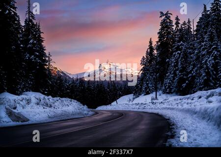 Winterstraße und Berggipfel bei Sonnenuntergang, Black Tusk bei Whistler. Stockfoto