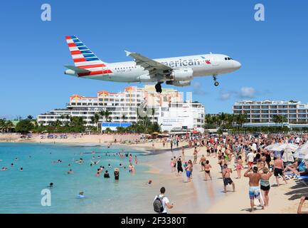 American Airlines Airbus A319 Flugzeuge, die tief über dem touristischen Maho Beach in Saint Maarten, Niederländische Antillen, fliegen. Flughafen Strand in St. Maarten. Stockfoto