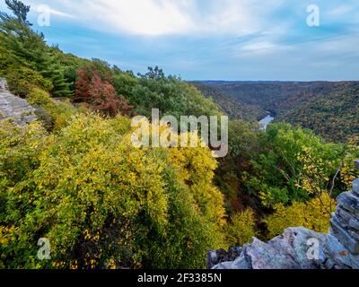 Blick auf die Berge und das Herbstlaub in Coopers Rock State Forest in West Virginia mit dem Sonnenuntergang golden Himmel eine Richtung und ein blauer Wirbel Stockfoto