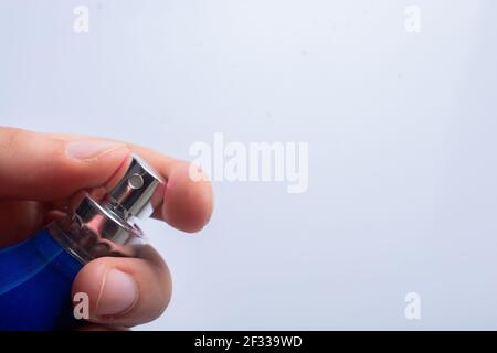 Drücken Sie die Taste, indem Sie die blaue Desinfektionsflasche aufsprühen. Schutz vor Viren, Gesundheitskonzept. Stockfoto