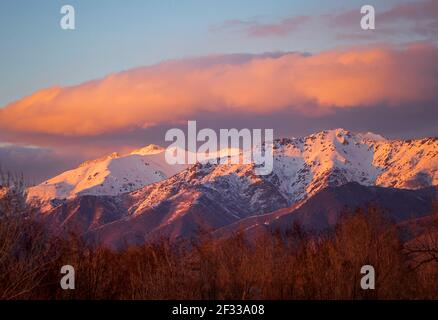 Dies ist ein Blick auf Mount Ogden, Utah (links) mit dem rosa Licht der untergehenden Sonne, von Kaysville, Davis County, Utah, USA im Süden gesehen. Stockfoto