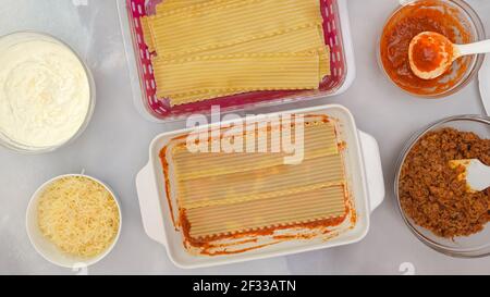 Rindfleisch Lasagne Schritt für Schritt Rezept. Lasagne zusammenbauen. Schicht Lasagne Nudeln und Zutaten schließen auf Küchentisch. Stockfoto