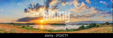 Schöne Landschaft mit bunten Sonnenuntergang über Wald, See Stockfoto