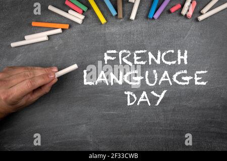 Tag Der Französischen Sprache 20 März. Graue Kreidetafel Hintergrund mit farbigen Stücken von Kreide. Stockfoto