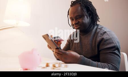 Online-Shopping, glücklicher junger Mann mit Smartphone für Online-Shopping und Zahlung mit Kreditkarte. Hochwertige Fotos Stockfoto
