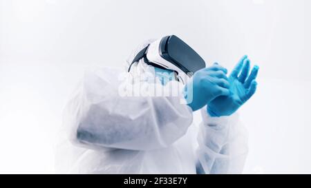afroamerikanischer schwarzer Arzt in Schutzuniform und mit VR-Brille Handschuhe anziehen. Hochwertige Fotos Stockfoto