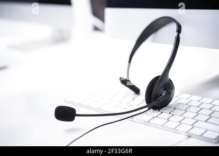 Mikrofon-Headsets auf dem Tisch mit Computer-Tastatur in Anruf Zentrieren Stockfoto