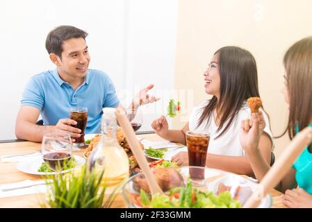 Leute genießen das Essen und Unterhaltung am Esstisch Stockfoto