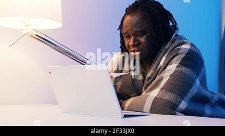 Mann mit Thermometer in der gescheuerten mit Online-Arzt Konsultationen gewickelt. Hochwertige Fotos Stockfoto