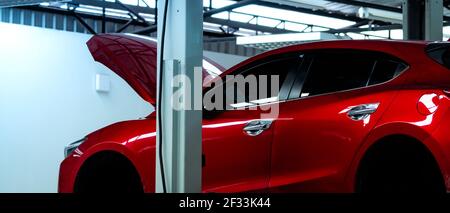 Autowerkstatt. Red SUV Auto ist Aufzug in der Garage für Reparatur-und Wartungsservice. Auto-Service mit angehobenen Fahrzeug. Karosserie in Werkstatt für angehoben Stockfoto