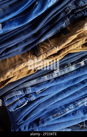 Stapel oder Stapel Jeans als Hintergrundtextur. Eine Menge gefalteter Jeans-Hosen Stockfoto