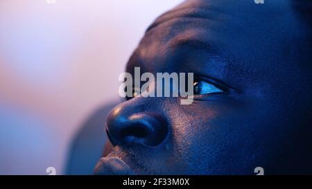 Schockierter Blick auf die Augen des afroamerikanischen schwarzen Mannes, der Textnachricht liest. Nahaufnahme. Hochwertige Fotos Stockfoto