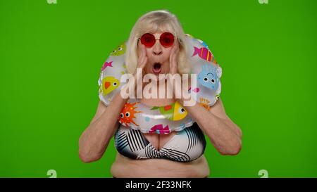 Schockiert Senior Rentner Frau Tourist in Badeanzug auf Chroma-Taste, wow spannende Überraschung Reaktion Stockfoto
