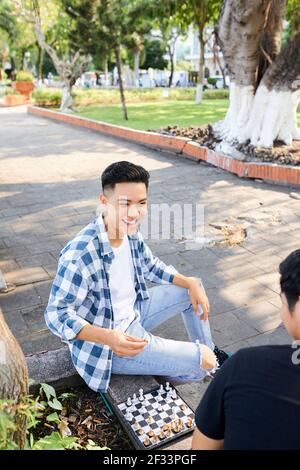 Asiatischer junger Mann, der zusammen mit seinem Freund Schach spielt Die Straße Stockfoto