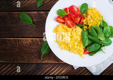 Frühstück. Rührei mit Kirschtomaten, Spinat und Mais. Draufsicht, flach liegend, oben Stockfoto