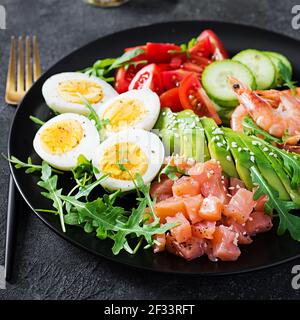 Ketogenic Diätfrühstück. Salatsalat mit gekochten Garnelen, Garnelen, Tomaten, Gurken, Rucola, Eier und Avocado. Keto, Paleo Lunch. Stockfoto