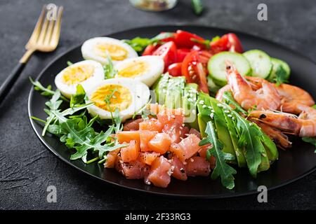 Ketogenic Diätfrühstück. Salatsalat mit gekochten Garnelen, Garnelen, Tomaten, Gurken, Rucola, Eier und Avocado. Keto, Paleo Lunch. Stockfoto