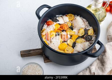 Eine Pfanne fabelhafter Fisch, mit Basmati-Reis und Kirschtomaten, auf weißem Hintergrund mit Platz für Text kopieren Stockfoto