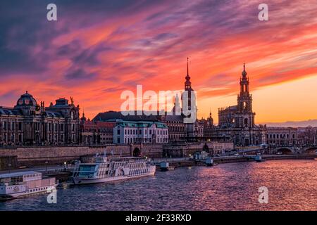 Roter Sonnenuntergang über dem Albertinum, dem Hausmannsturm und der Dreifaltigkeitskathedrale in der Altstadt, über der Elbe gesehen. Stockfoto