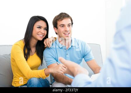 Junges Paar Treffen mit Berater (oder Berater, Finanzberater, Immobilienmakler etc.) Stockfoto