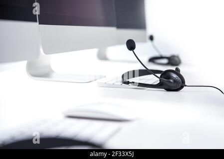 Mikrofon-Headsets auf dem Tisch mit Computer-Tastatur - Anruf Center-Konzept Stockfoto