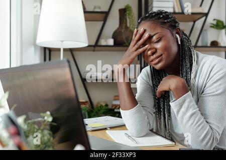 Traurige schwarze weibliche Studentin fast weinen, nachdem sie nicht Text übergeben Online beim Studieren zu Hause Stockfoto